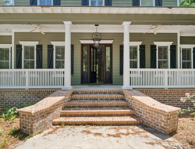 Front exterior of a Richmond Hill, GA home with columns and a green lawn